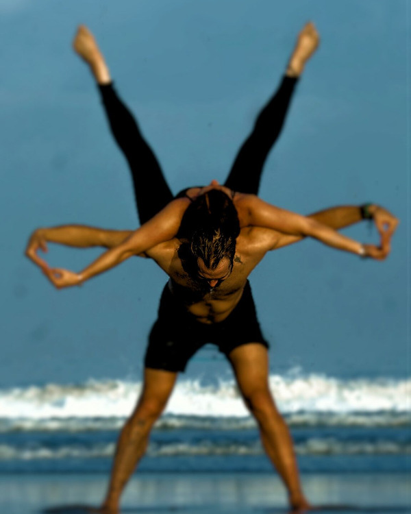 Couple performing AcroYoga at the beach.